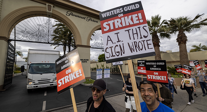 LOS ANGELES, CA - MAY 04: People picket outside of Paramount Pictures studios during the Hollywood writers strike on May 4, 2023 in Los Angeles, California. Scripted TV series, late-night talk shows, film and streaming productions are being interrupted by the Writers Guild of America (WGA) strike. In 2007 and 2008, a WGA strike shut down Hollywood productions for 100 days, costing the local economy between $2 billion and $3 billion. (Photo by David McNew/Getty Images)