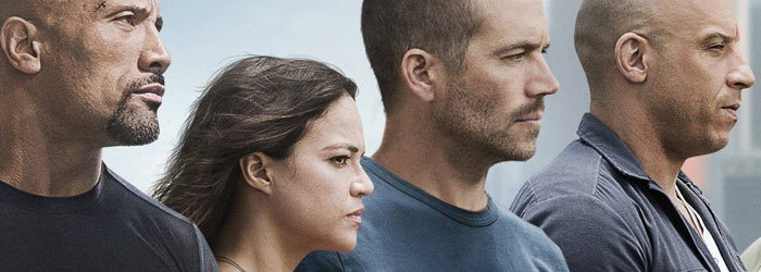Dwayne Johnson, Michelle Rodriguez, Paul Walker and Vin Diesel on the poster for Furious 7 (2015)