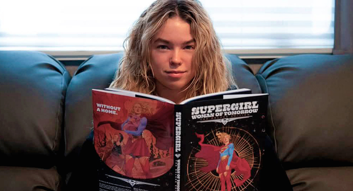 Milly Alcock with a copy of the Supergirl comic book Woman of Tomorrow.